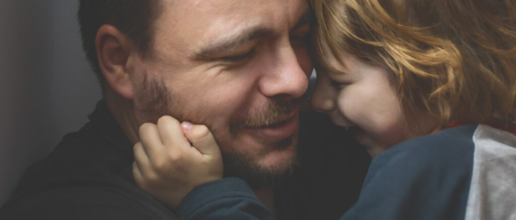 father and son kissing and hugging